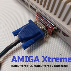 Könnte beinhalten: Ein blaues VGA-Kabel, das in eine rote Platine gesteckt ist, mit dem Text "AMIGA Xtreme! (Unbuffered-LC / Unbuffered / Buffered)" auf einer weißen Oberfläche.