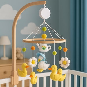 Pode incluir: Móvel de bebê de madeira com uma estrutura circular, apresentando patinhos de feltro, margaridas e um pato com chapéu. O móvel inclui uma chaleira e pompons coloridos, suspensos de um braço de madeira. O fundo é azul claro.