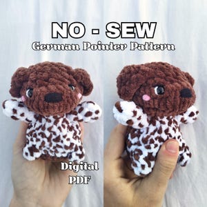 Puede incluir: Dos peluches de perro Pointer alemán tejidos a ganchillo. Los perros son marrones y blancos, con ojos y narices negros. El texto "NO - SEW German Pointer Pattern" y "Digital PDF" es visible.