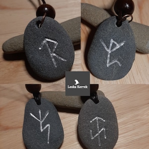 May include: Four grey stone pendants with white etched runes, each on a black cord with a brown wooden bead. The runes are: Algiz, Sowilo, Isa, and Jera.