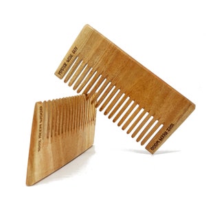 May include: Two wooden combs, one on top of the other. The top comb is labeled "100%  MEEH WOOD" and "MYSTER WISE GUY". The bottom comb is labeled "100% MEEH WOOD".