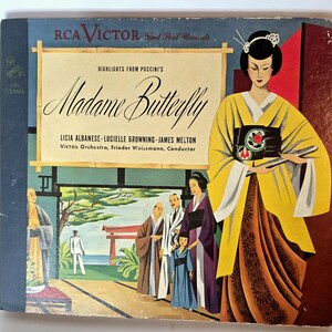May include: Vintage RCA Victor record album cover for "Madame Butterfly." The cover features an illustration of a woman in a yellow kimono, with a Japanese-style scene in the background. The album title and artist names are displayed prominently.