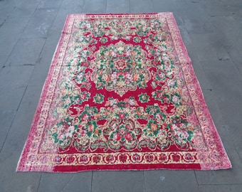 Könnte beinhalten: Ein roter Vintage-Teppich mit einem floralen Muster in Grün-, Gelb- und Weißtönen. Der Teppich hat einen detaillierten Rand mit einem sich wiederholenden Muster.