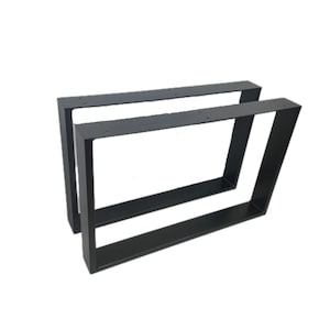 Könnte beinhalten: Zwei schwarze Metall-Tischbeine in modernem, geometrischem Design. Jedes Bein ist rechteckig mit einer schrägen Stütze und vorgebohrten Löchern zur einfachen Befestigung. Die Beine sind aus robustem Metall gefertigt.