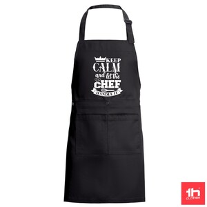 Könnte beinhalten: Schwarze Schürze mit einem weißen Aufdruck, der "Keep Calm and Let the Chef Handle It" lautet.