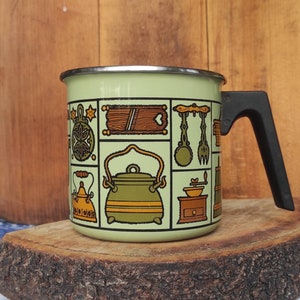 Vintage green one handle enameled pot decorated with kitchen motifs in the folk art style made in Yugoslavia