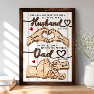 May include: Wooden framed family sign with the text "The only thing better than having you as my Husband" and "is our children having you as their Dad". Includes names Thomas, Amelia, Noah, and Emily.