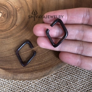 May include: Two dark brown wooden square hoop earrings. The earrings are slightly angled and have a smooth, polished finish.