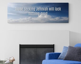 May include: A blue armchair with a gray throw pillow sits in front of a fireplace with a black screen. A woven basket filled with logs sits on a blue rug in front of a white wall with a canvas print that reads "Those seeking Jehovah will lack nothing good - Psalm 34:10".