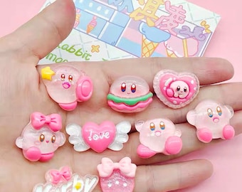 May include: A set of ten pink and white resin charms featuring Kirby characters. The charms include Kirby in various poses, a heart with the word "love" on it, and a charm with the word "Kirby" on it.