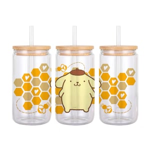 Puede incluir: Tres vasos de vidrio transparentes con tapas de bambú y pajitas. Cada vaso presenta un perro de dibujos animados con un patrón de panal y corazones.