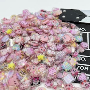 Puede incluir: Un gran surtido de pegatinas de resina transparente rosa y blanca con varios personajes de dibujos animados, incluyendo un personaje rosa con una estrella en el pecho, un personaje rosa con una corona y un personaje rosa con un arcoíris. Las pegatinas son perfectas para añadir un toque de fantasía a los diarios, planificadores y otros proyectos de manualidades.