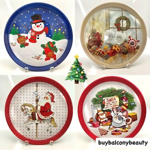 Puede incluir: Conjunto de cuatro bandejas de servir de metal vintage con temática navideña. Las bandejas presentan un muñeco de nieve, gatitos, Papá Noel en un carrusel y un ratón con un árbol de Navidad.