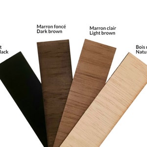 Puede incluir: Cuatro tiras rectangulares de madera dispuestas en abanico, que muestran diferentes acabados: negro mate, marr&oacute;n oscuro, marr&oacute;n claro y madera natural. Cada tira est&aacute; etiquetada con el nombre de su color en franc&eacute;s e ingl&eacute;s.