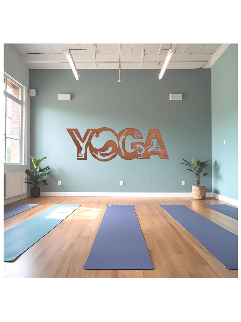 Puede incluir: Un letrero de pared met&aacute;lico de color marr&oacute;n con la palabra YOGA en letras may&uacute;sculas, donde cada letra contiene siluetas recortadas de personas realizando diversas posturas de yoga, montado en una pared azul claro sobre varias esterillas.
