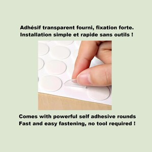 Puede incluir: Una hoja de adhesivos circulares transparentes dispuestos en cuadr&iacute;cula sobre un soporte blanco. El texto dice: Adh&eacute;sif transparent fourni, fixation forte. Installation simple et rapide sans outils ! Comes with powerful self adhesive rounds.