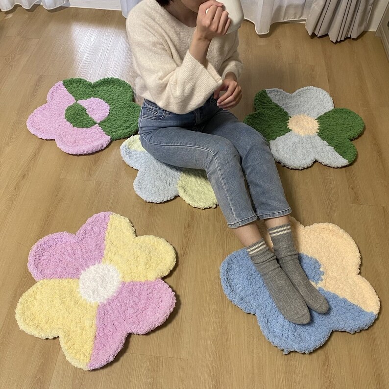 May include: Four colorful flower-shaped rugs in shades of pink, yellow, green, and blue. The rugs are made of soft, fluffy material and are perfect for adding a touch of whimsy to any room.