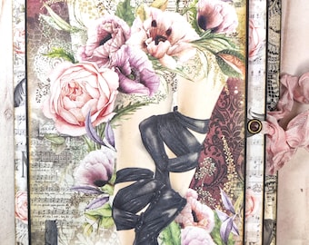 Può includere: Un album di scrapbooking in stile vintage con un design floreale e un bordo in pizzo nero. La copertina presenta un'illustrazione ad acquerello di gambe di donna con scarpe nere e un mazzo di fiori. L'album è chiuso e ha un nastro rosa legato intorno.
