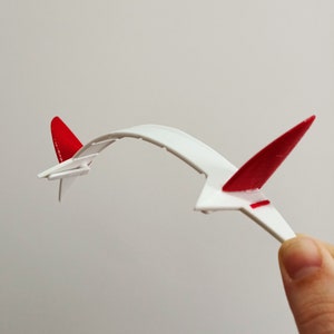 May include: White headband with two red devil horns. The headband is flexible and can be adjusted to fit most head sizes.