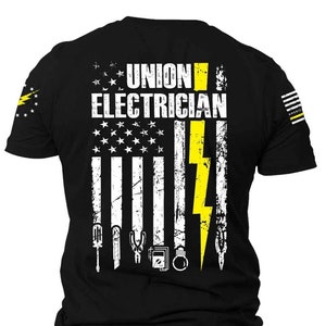 K&ouml;nnte beinhalten: Schwarzes T-Shirt mit einem abgenutzten amerikanischen Flaggen-Design mit einem gelben Blitz und dem Text "UNION ELECTRICIAN".