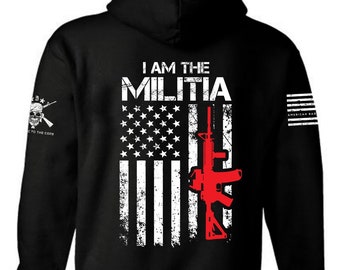 May include: Black hooded sweatshirt with a distressed American flag design featuring a red rifle and the text "I AM THE MILITIA".