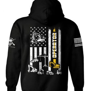 May include: Black hooded sweatshirt with a white American flag design featuring construction equipment silhouettes and the text "OPERATOR" in yellow. The sleeve has a small skull and crossbones graphic with the text "TO THE CORE".