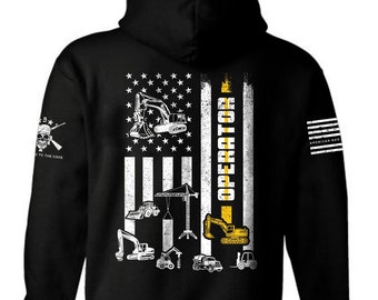 May include: Black hooded sweatshirt with a white American flag design featuring construction equipment silhouettes and the text "OPERATOR" in yellow. The sleeve has a small skull and crossbones graphic with the text "TO THE CORE".