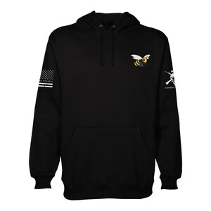 May include: Black hooded sweatshirt with a bee graphic on the front and an American flag and a rifle graphic on the sleeves. The text "PATRIOTIC APPAREL" is on the right sleeve.
