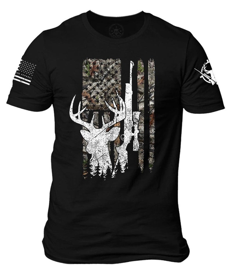 May include: Black t-shirt with a white deer and rifle silhouette on a camouflage American flag design.