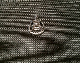 May include: A silver charm in the shape of a woman wearing a crown and holding a heart. The charm is detailed and intricate.
