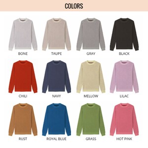 May include: A grid of twelve long-sleeve crewneck sweaters in various colors labeled Bone, Taupe, Gray, Black, Chili, Navy, Mellow, Lilac, Rust, Royal Blue, Grass, and Hot Pink. Each sweater features a solid color and a ribbed neckline.