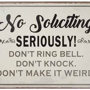 May include: A white metal sign with a distressed look, featuring the text "No Soliciting Seriously! Don't ring bell. Don't knock. Don't make it weird."
