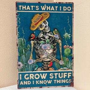 May include: A metal sign with a blue background and a skeleton wearing a straw hat and holding a pot of flowers. The sign says "That's what I do I grow stuff and I know things".