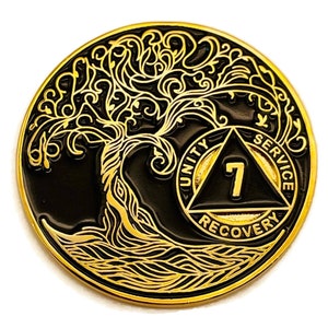 May include: Gold-toned metal coin with a black background featuring a stylized tree with intricate branches and roots. The coin also features a black triangle with the words "Unity", "Service", and "Recovery" inscribed around it. The number "7" is centered in the triangle.