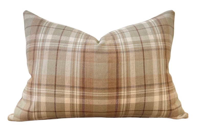 May include: A brown and beige plaid cushion with a soft, textured fabric.