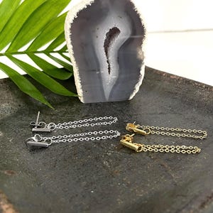 Peut inclure: Une paire de boucles d'oreilles avec un design de chaîne. Une paire est argentée et l'autre est dorée.