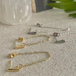 Peut inclure: Trois paires de boucles d'oreilles pendantes avec une chaîne et un petit pendentif en forme de barre. Les boucles d'oreilles sont en or, argent et or rose.