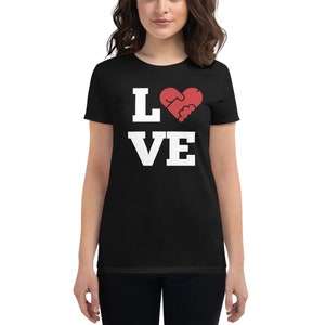 Puede incluir: Camiseta negra con texto blanco que dice "LOVE" con un s&iacute;mbolo de coraz&oacute;n rojo que es un apret&oacute;n de manos.