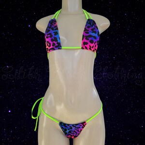 May include: A neon green and rainbow leopard print bikini top and matching thong. The top has adjustable straps and a halter style. The thong has a low rise and a cheeky cut.