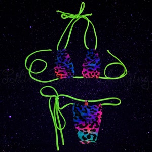 May include: A neon green bikini with a leopard print pattern in shades of pink, blue, and black. The bikini top is a triangle style with adjustable straps. The bikini bottom is a cheeky style with a high leg cut.