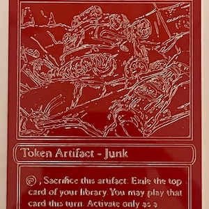 Op de afbeelding: Een rode ruilkaart met het woord "Junk" bovenaan. De kaart toont een gedetailleerde witte lijntekening van een hoop schroot. De tekst "Token Artifact - Junk" staat onder de afbeelding, samen met spelinstructies.