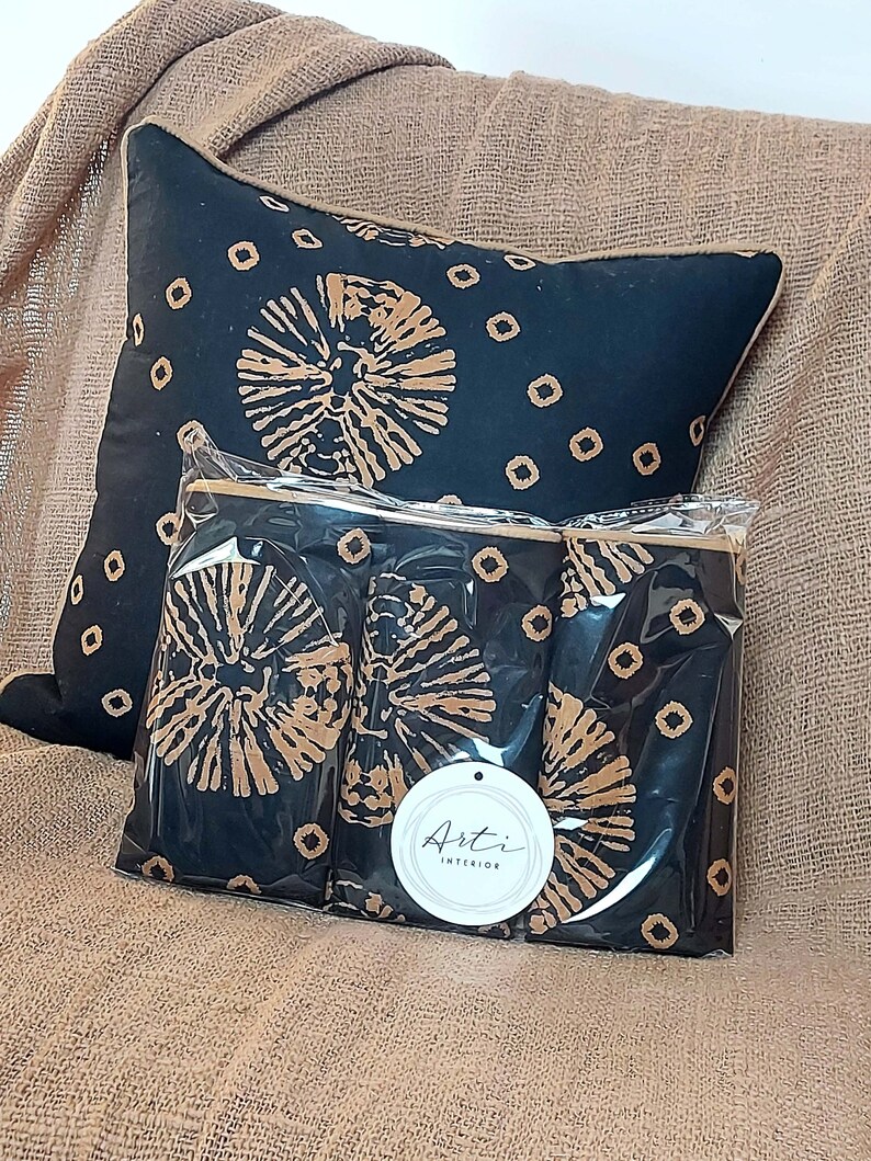 May include: Three black and brown patterned throw pillows with a white tag that says "Arti Interior".