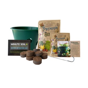 May include: A green hanging planter with a brown soil disc, a packet of seeds, a packet of coconut coir, and a metal hook. The seed packet has a vintage design and says "Premium Seeds". The coconut coir packet says "Minute Soil+ Amended Coconut Coir Water Retention Mix". The seed packet has a picture of various vegetables and herbs. The coconut coir packet has a picture of a plant.