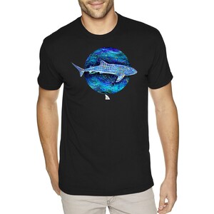 K&ouml;nnte beinhalten: Schwarzes T-Shirt mit einer Illustration eines blauen und gr&uuml;nen Walhais in einem Kreis.