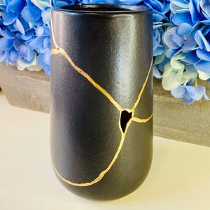Kintsugi keramik, svart vas, stengodskonst med guldfärgade lagningslinjer, heminredning