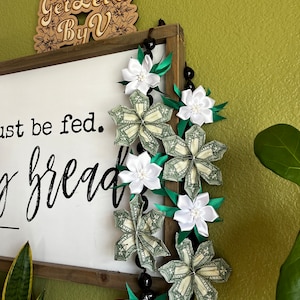 Lei de nuez de kukui con plumerias inspiradas en dinero y cinta blanca