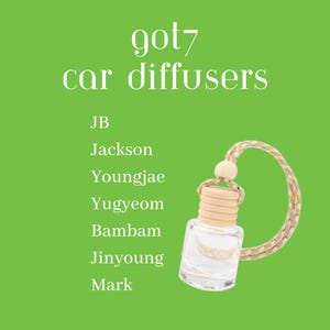 May include: A clear glass car diffuser with a wooden cap and a decorative cord. The text "got7 car diffusers" is at the top, with a list of names below. The background is a solid green.