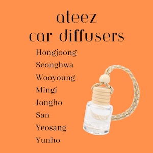 May include: An orange background with the text "ateez car diffusers" and a list of names. A small, clear glass bottle with a wooden cap and a decorative cord is shown. The bottle is designed to be used as a car air freshener.