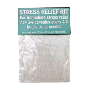 May include: A clear bubble wrap pouch with a teal and white label that reads "STRESS RELIEF KIT". The label provides instructions for immediate stress relief, suggesting popping 3-4 capsules every 4-6 hours or as needed.