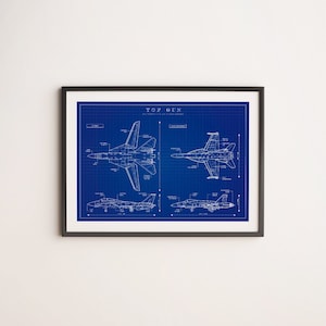 Puede incluir: Impresión enmarcada estilo plano, con diagramas detallados de aviones de combate sobre un fondo de cuadrícula azul. El texto "TOP GUN" está en la parte superior. El marco negro añade un toque clásico a esta obra de arte de temática aeronáutica.